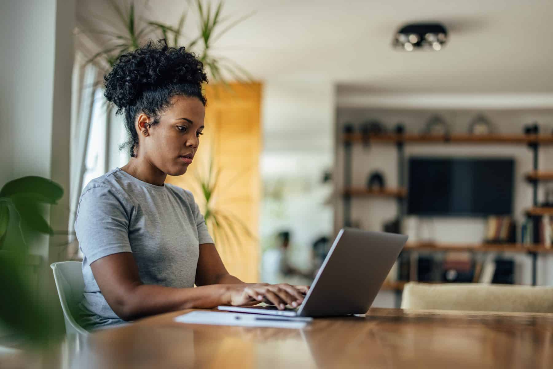A woman researches details about substantial gain activity at home with her laptop.