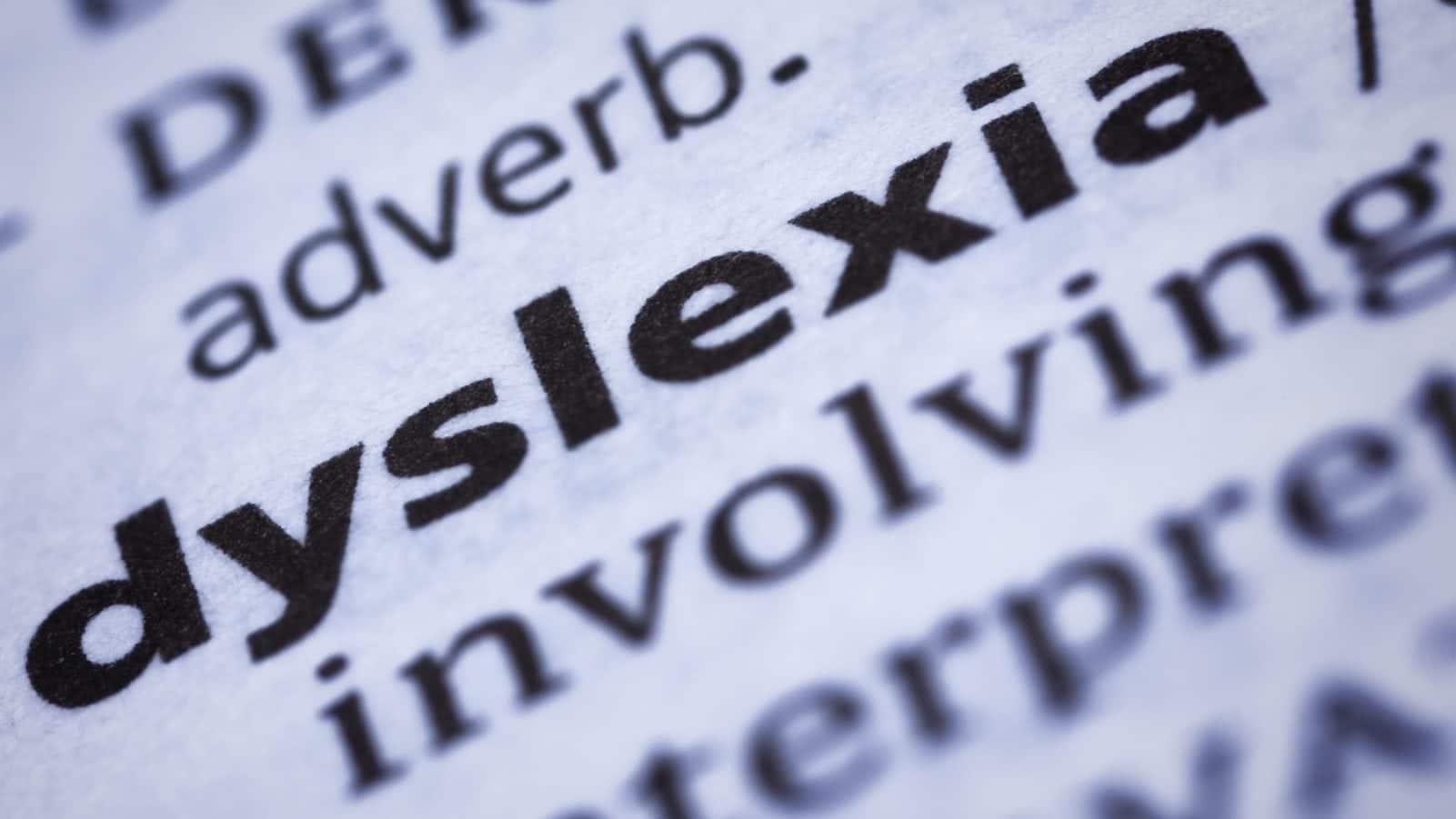 Close-up of the word "dyslexia" in bold print from a dictionary, with surrounding text slightly blurred.