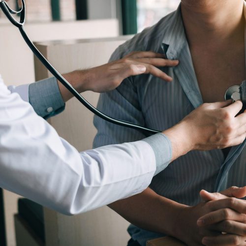 Doctor examining sick male patient